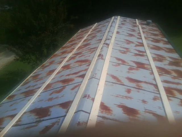 Rusted metal roof panels with new wood purlins before replacement — Storm Damage Roof Repair in Millville by Roofing Brothers